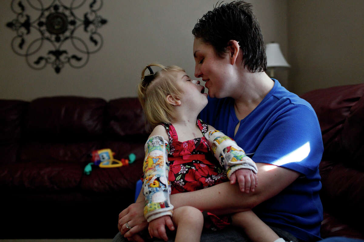 Stephanie Barnett holds her adopted daughter, Maclayne, 4, who has Down syndrome and was born with fetal alcohol syndrome, at their home in San Antonio on Dec. 18, 2012.