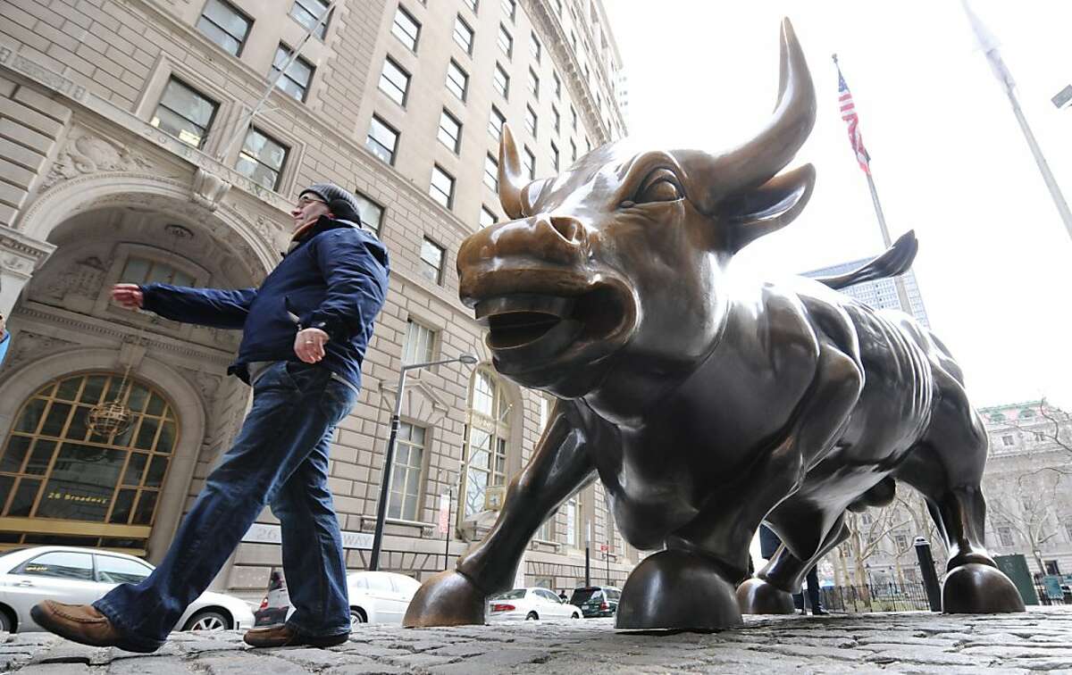 A tourist walks past the symbol of prosperity in the financial markets on lower Broadway in New York, Thursday, Jan. 24, 2008. Wall Street sought to extend its gains Thursday, fluctuating as investors absorbed more bad news about bond insurers but received economic data that suggested the job market remains largely intact. (AP Photo/Henny Ray Abrams)