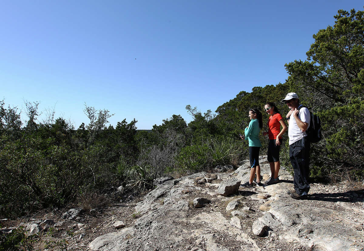 Don (from left), Alex and her friend Rachel (last names withheld) reach the top of a bluff during a hike on a trail at Government Canyon State Park on Tuesday, Dec. 25, 2012. The park remained open from Christmas until January 7th in an effort to attract more visitors as well as to validate funding for the parks by the legislature. The trio of hikers were amongst a small group of people who took advantage of the mild temperatures on Christmas day to visit the park.