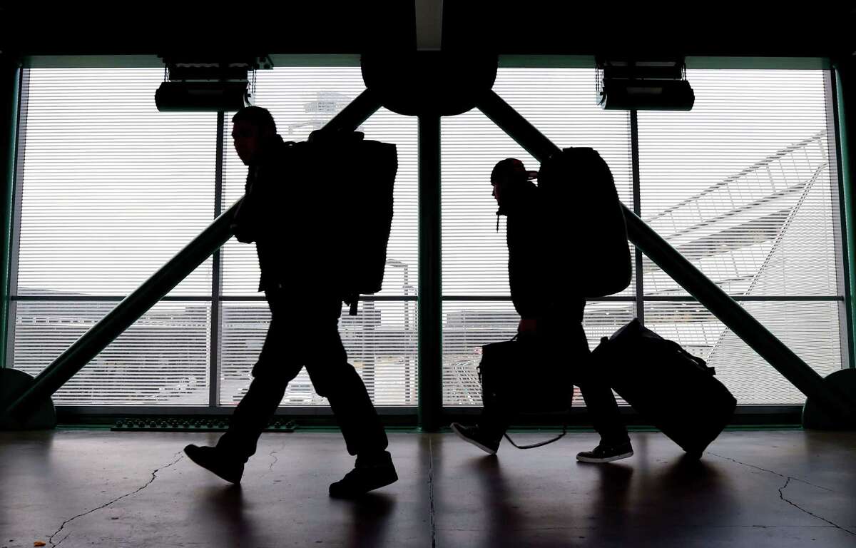 This Dec. 21, 2012 file photo shows travelers walking to a ticketing desk at O'Hare International Airport in Chicago. For many passengers, air travel is only about finding the cheapest fare. But as airlines offer a proliferating list of add-on services, from early boarding to premium seating and baggage fees, the ability to comparison-shop for the lowest total fare is eroding. (AP Photo/Nam Y. Huh, File)
