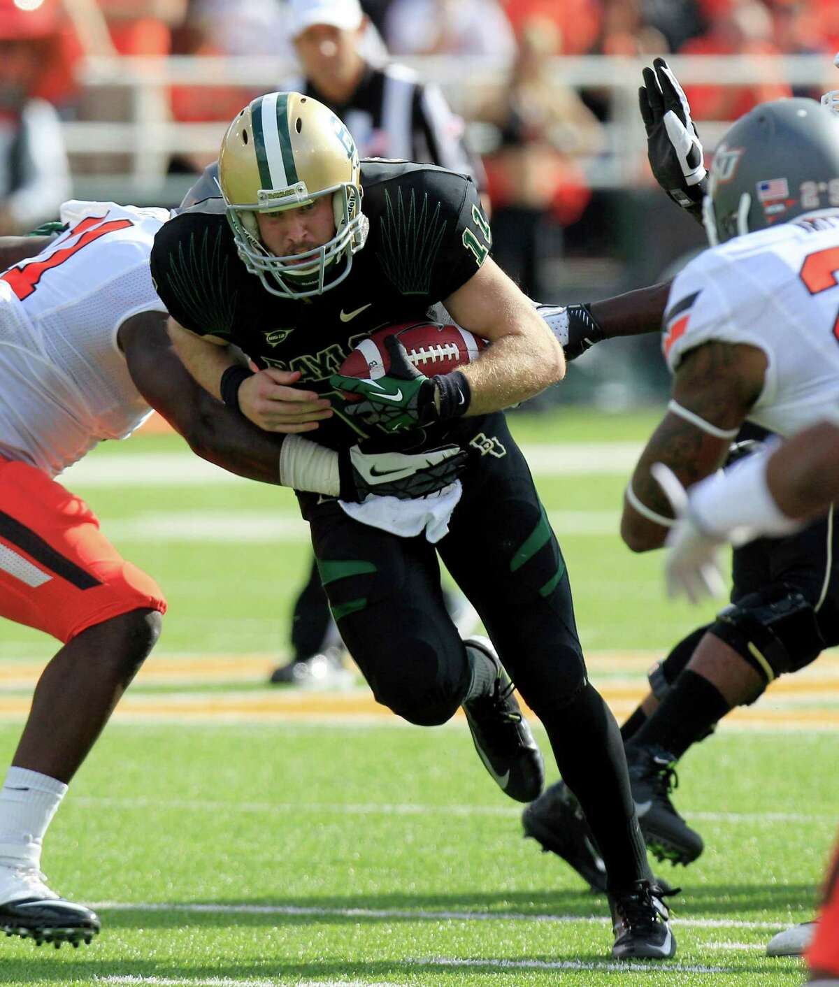 Baylor quarterback Nick Florence (11) runs on the keeper against Oklahoma State linebacker Shaun Lewis (11) during the second half of an NCAA college football game, Saturday, Dec. 1, 2012, in Waco, Texas. Baylor won 41-34. (AP Photo/LM Otero)