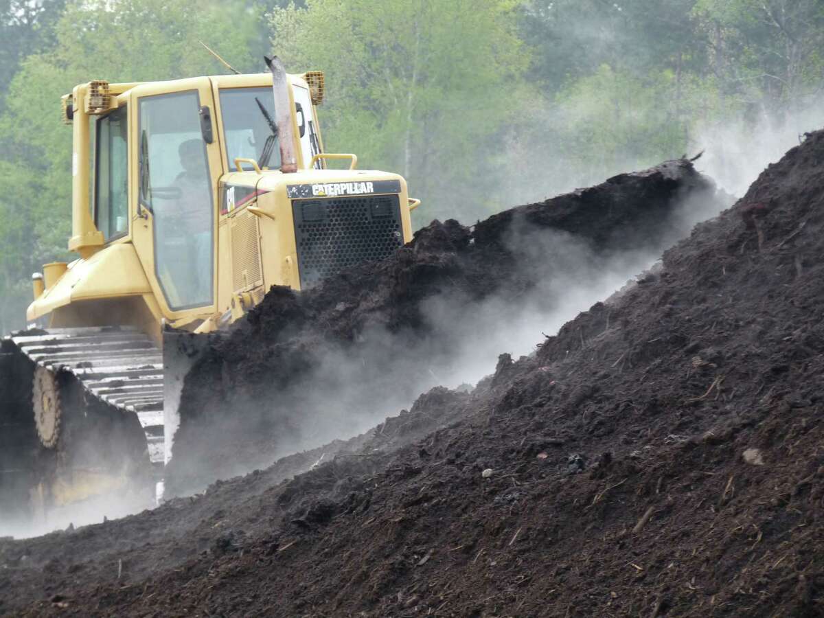 A bulldozer turns a pile of compost - which must contain the right mix of soil, organic material, food waste, bacteria and fungi.