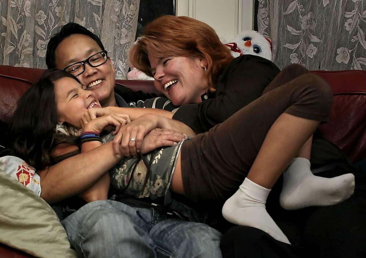 MeiBeck "Chino" Scott-Chung, (left) and Maya Scott-Chung with their 8-year-old daughter Luna at their Oakland Calif. home on Thursday Dec. 6, 2012. Partners, Maya Scott-Chung and MeiBeck "Chino" Scott-Chung wanted to have a child and they wanted to use the sperm of a trusted male friend. Under federal law, the donor would have had to be tested within a week of every attempt to conceive, a process that could cost thousands of dollars. Scott-Chung unknowingly circumvented those rules and gave birth to a young daughter. But a new California law that takes effect Jan. 1 and was authored by Assemblywoman Nancy Skinner (D-Berkeley) intends to make that process easier for other LGBT families, single/low-income women and heterosexual couples who need help conceiving.