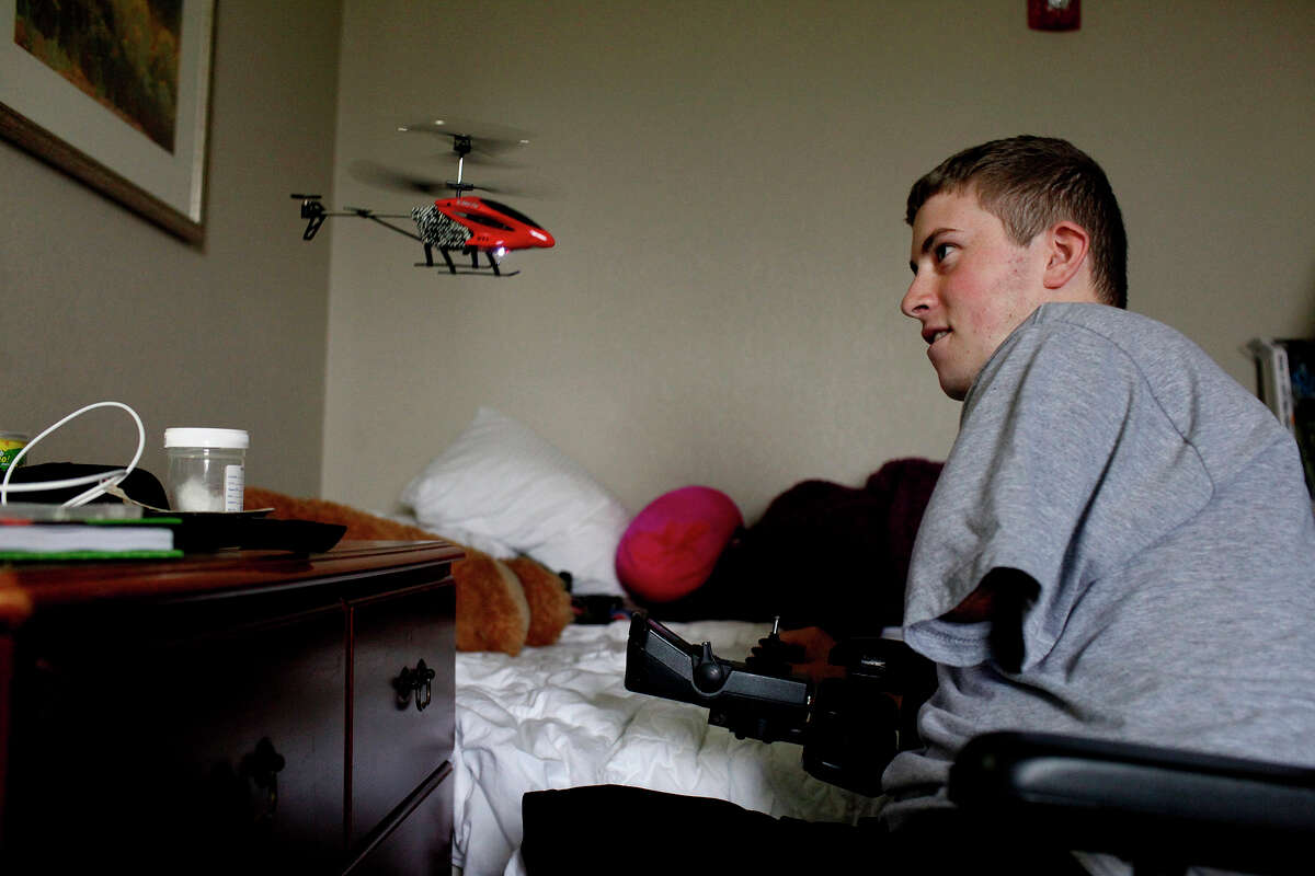 Army Pfc. Kevin Trimble, 19, entertains himself with a remote controlled helicopter in the room he shares with his mother, Saralee Trimble, at Powless Guest House at Fort Sam Houston in San Antonio on Wednesday, March 7, 2012.