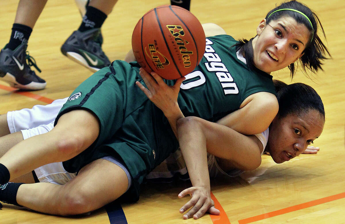 Rattler point guard Tessa Ramirez passes the ball away after winning a scramble on the floor against Ebony Easter as the Reagan girls defeat O'Connor 45-42 in basketball playoff action at the UTSA Convocation Center on February 16, 2012.