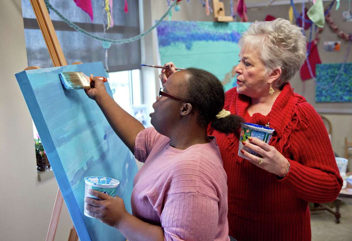 12/10/12: Volunteer Connie Harmon monitors Chanta Burton on her painting at the Melody McDowell Art Center , located at the Texana Center in Rosenberg, Texas.