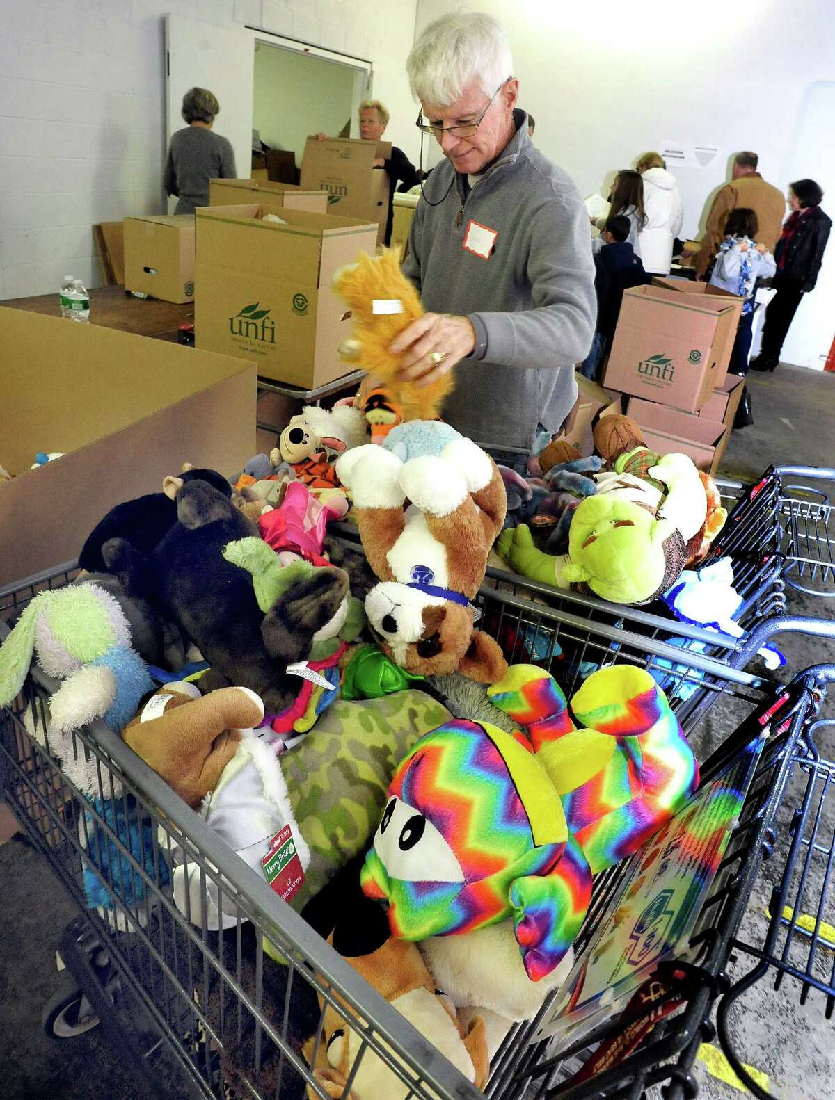 Volunteers, including Frank Gardner, sort donated stuffed animals in a Simms Lane warehouse in Newtown Thursday, Dec. 27, 2012.
