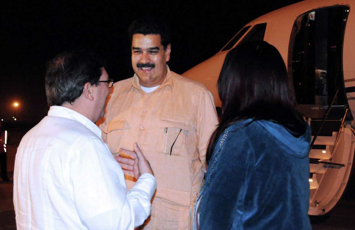 In this photo provided by Cuba's state newspaper Granma, Cuban Foreign Minister Bruno Rodriguez , left, talks with Venezuela's Vice President Nicolas Maduro, center, as Venezuelan Attorney General Cilia Flores watches at the Jose Marti International Airport in Havana on Saturday, Dec. 29, 2012. Maduro arrived in Cuba to visit Venezuelan President Hugo Chavez, who is recovering from a surgery_ his fourth operation related to his pelvic cancer since June 2011. (AP Photo/Granma, Juvenal Balan Neyra )