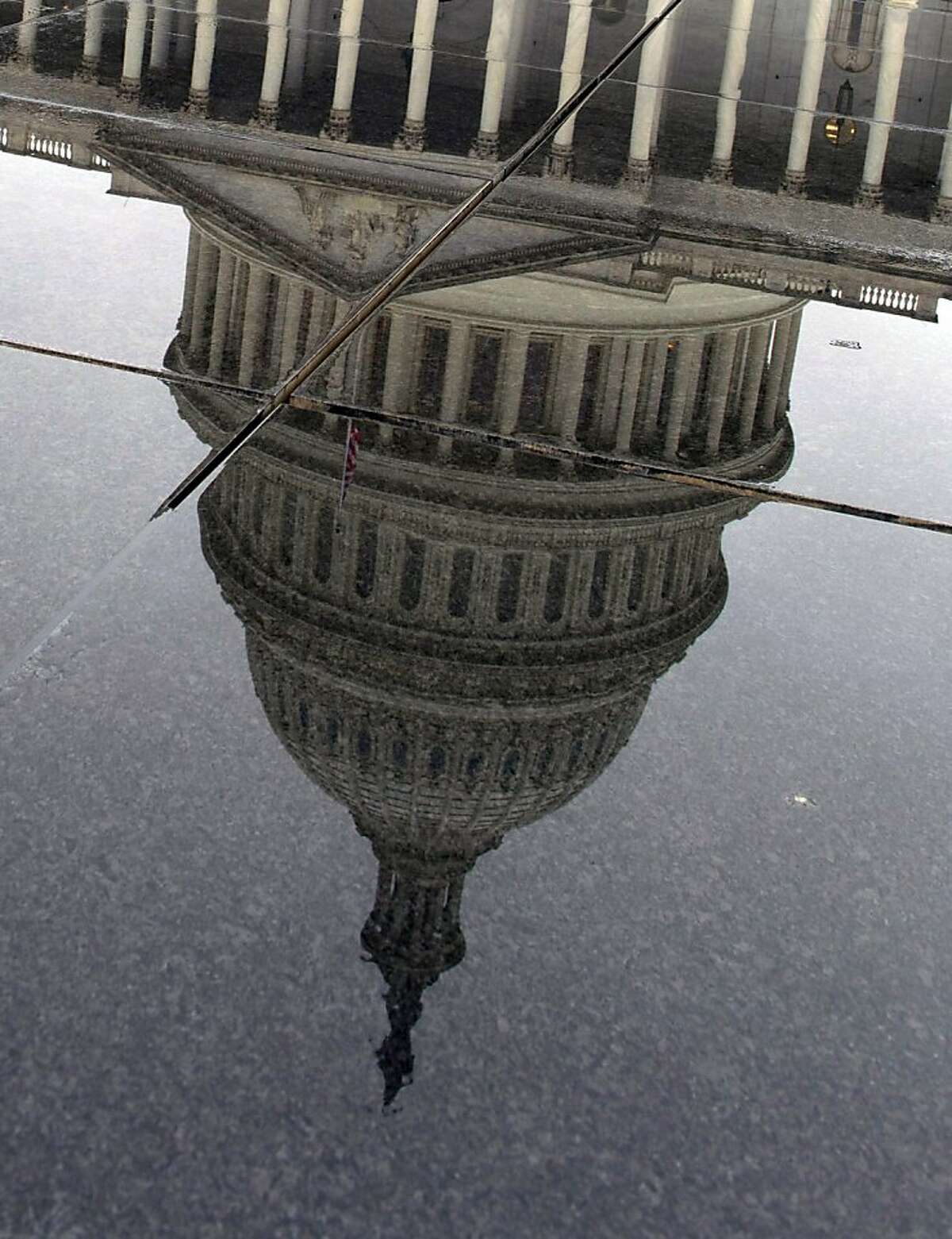 The US Capitol is reflected in rainwater on Capitol Hill in Washington, DC on December 29, 2012. As the fiscal cliff deadline looms, Congress and the White House have still not reached a compromise. If no deal is struck by December 31 at midnight, taxes will automatically go up on both high earners and the middle class, and across-the-board spending cuts will go into effect. AFP PHOTO/Karen BLEIERKAREN BLEIER/AFP/Getty Images