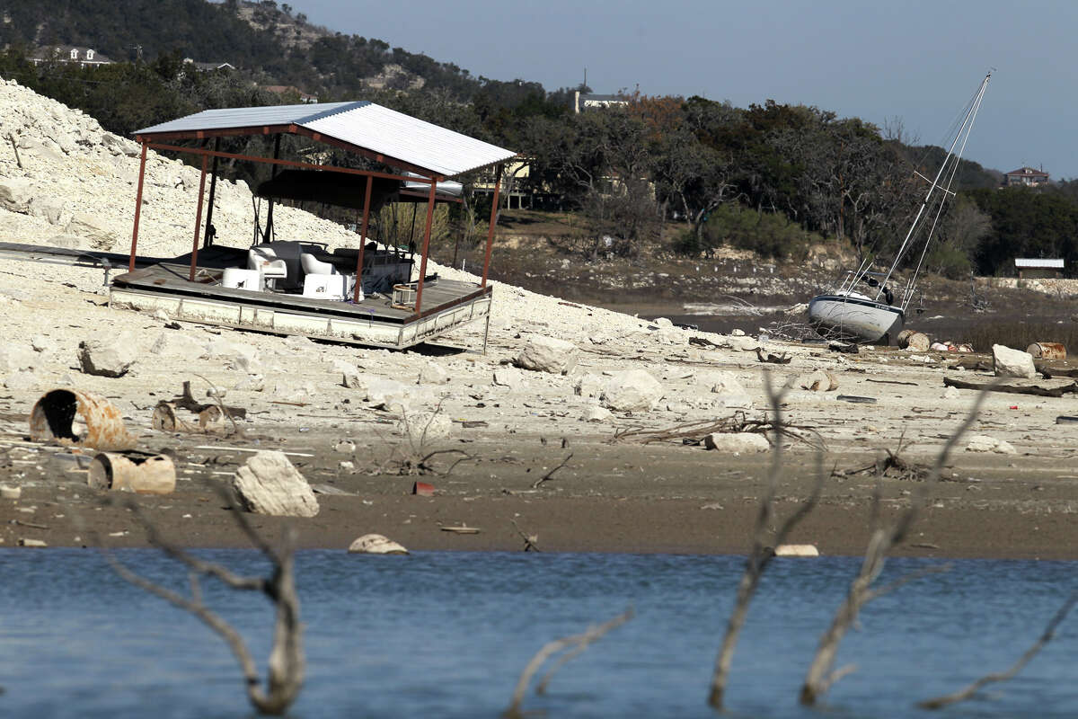 In this Jan. 19, 2012 photo, a sailboat lists on its side on the ground next to a beached dock as water levels at Medina Lake, Texas continued to drop.
