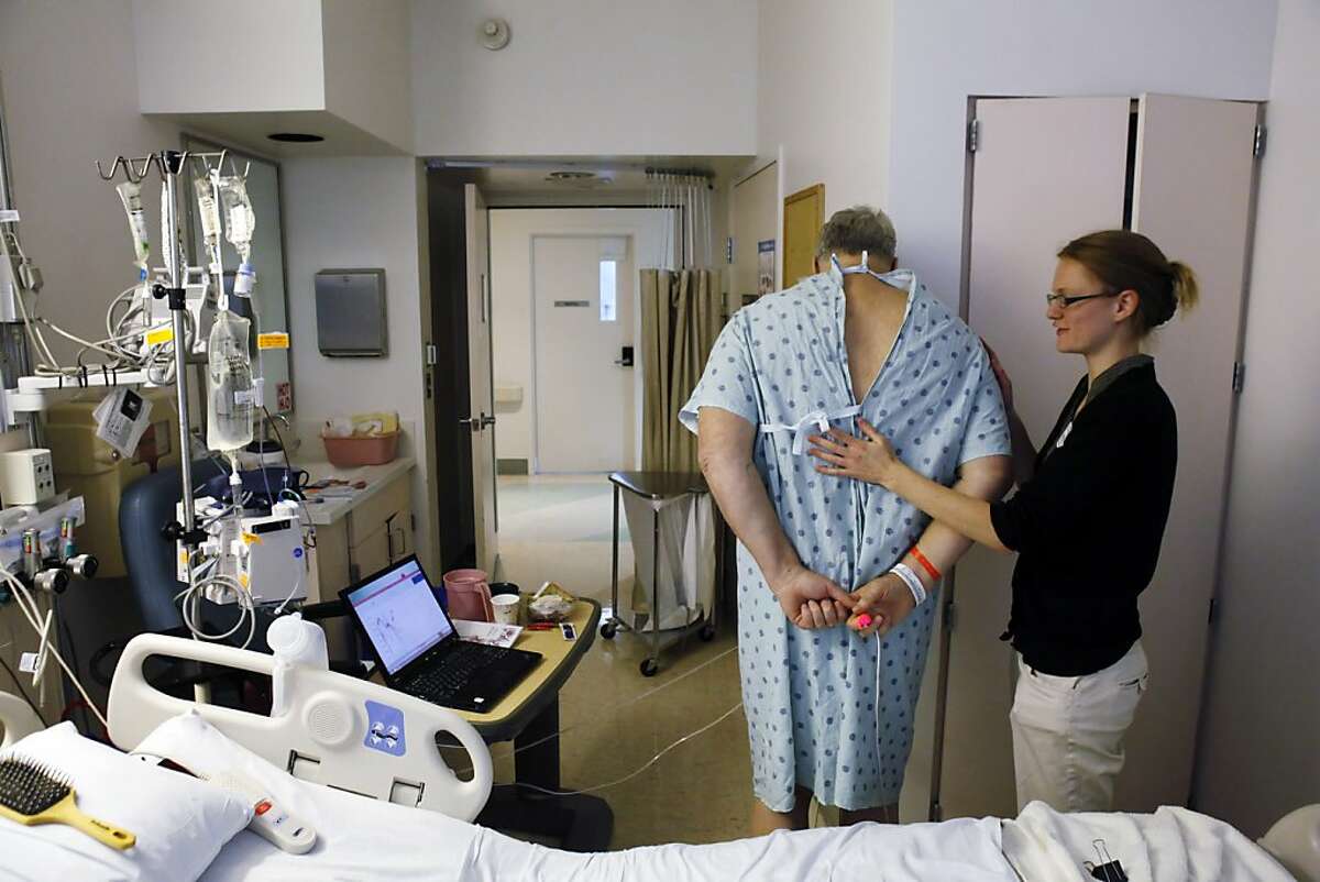 Greg Little, left, stands on a scale as Kendra Johnson, right, a fourth-year medical student at UCSF, checks on him in his hospital room at UCSF Medical Center in San Francisco, Calif., on Monday, December 17, 2012. Johnson was running a test study to see if a bathroom scale-like device could monitor vital signs and Little was part of the study. Johnson is currently looking for residencies in primary or family care because she feels those doctors bring down medical costs by focusing on prevention.