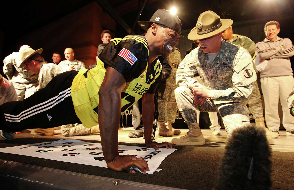 Antwuan Davis (left) from Bastrop, Texas grimaces as he performs push-ups with encouragment from drill sergeant leader Christopher Offringa as part the first-ever All-American Soldier-Hero Challenge at Sunset Station on Wednesday, Jan. 2, 2013. Players, band members and soldiers teamed up to compete in sit-ups, push-ups and an eating contest as part of one of many events leading up to Saturday's U.S. Army All-American Bowl game which highlights some of the best high school football players in the country.