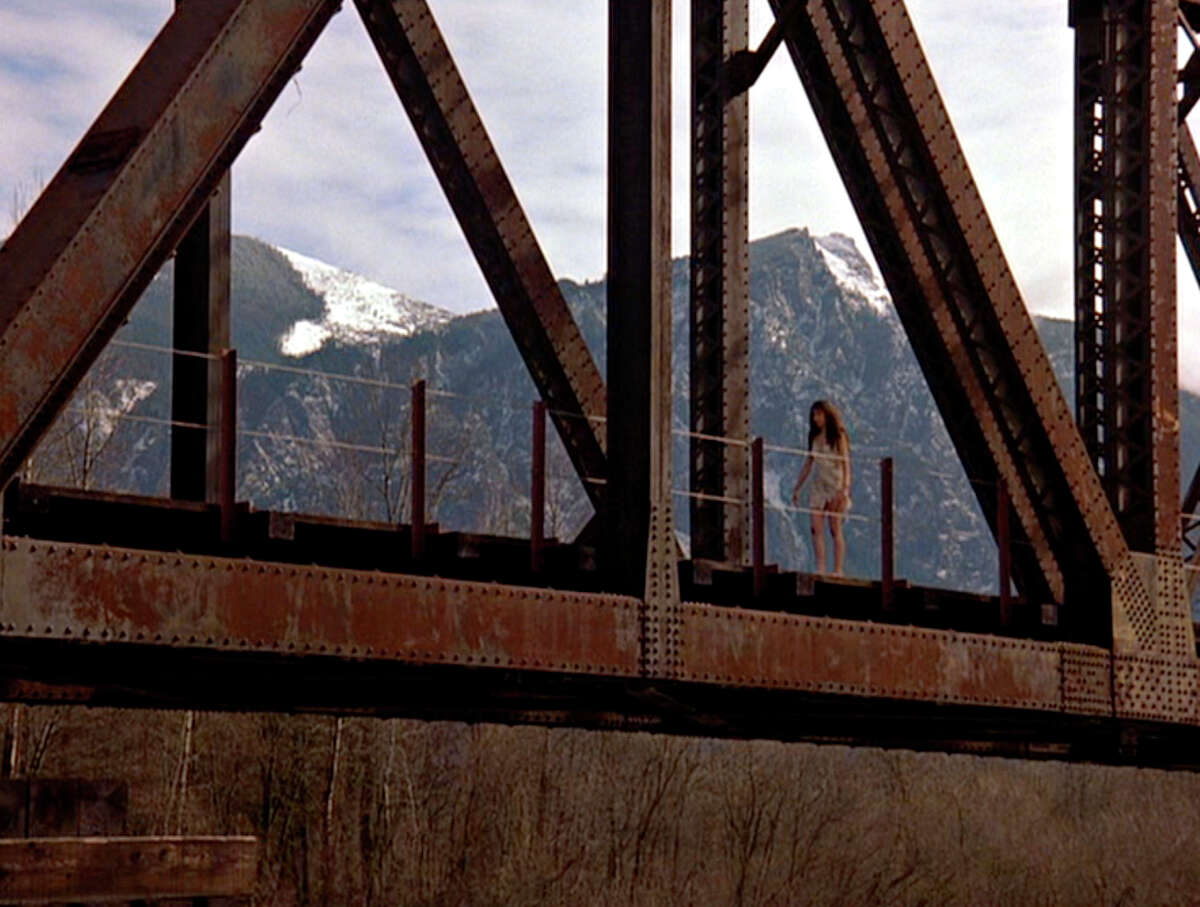 American actress Phoebe Augustine (as Ronette Pulaski) walks across a railroad trestle (the Reinig Bridge) in a scene from the pilot episode of the television series 'Twin Peaks,' originally broadcast on April 8, 1990. (Photo by CBS Photo Archive/Getty Images)