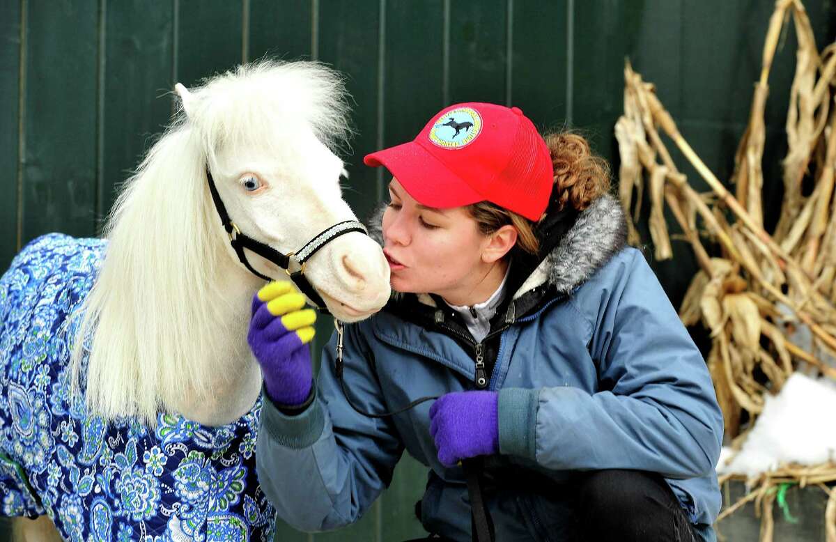 Therapy volunteer Jennifer Anfinsen cuddles with Aladdin, one of the Gentle Carousel Miniature Therapy Horses visiting The Ridge Equestrian Center in Newtown Friday, Jan. 4, 2012.