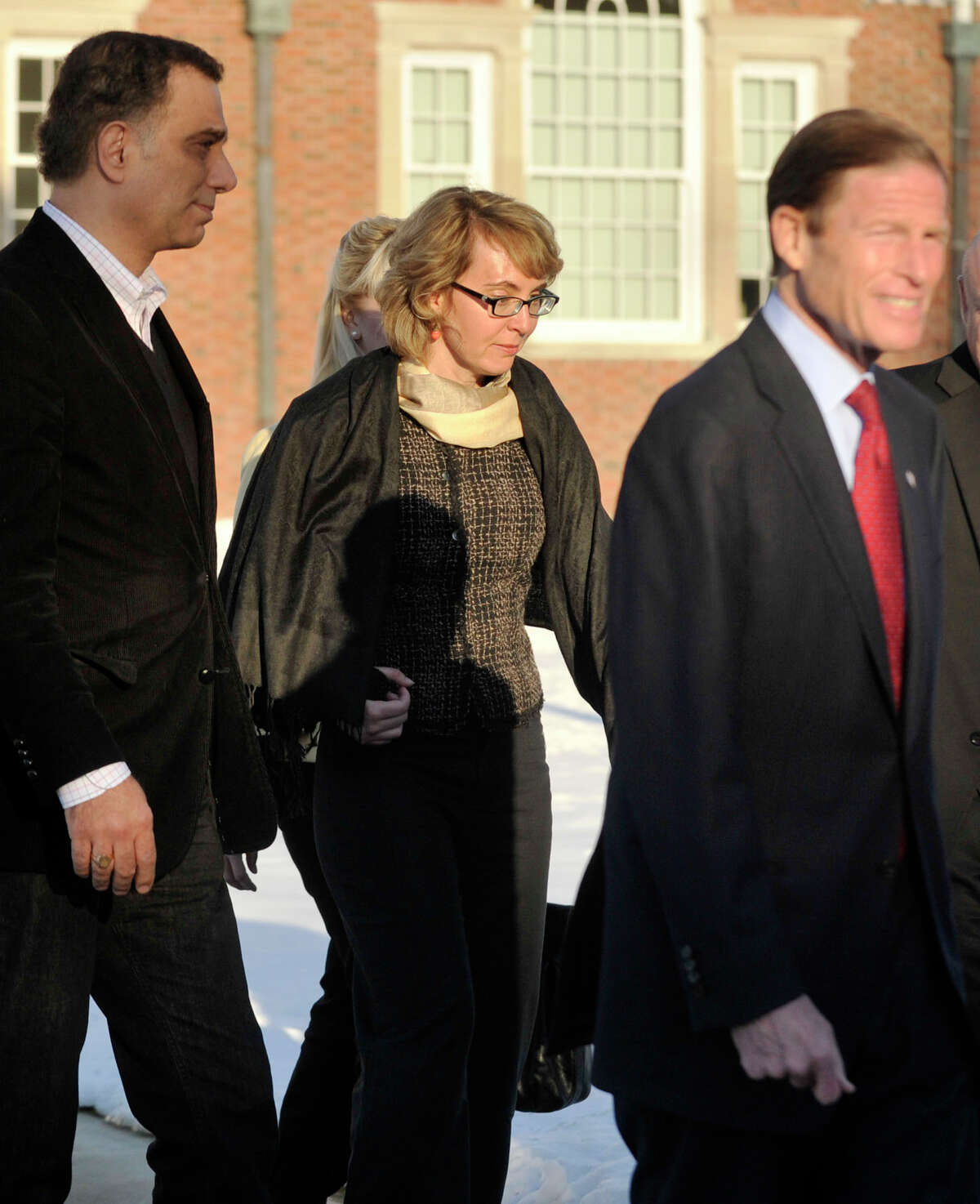 Former Congresswoman Gabrielle Giffords, center, exits Newtown Town Hall at Fairfield Hills Campus after meeting with Newtown First Selectman Pat Llodra and other officials on Friday, Jan. 4, 2013.