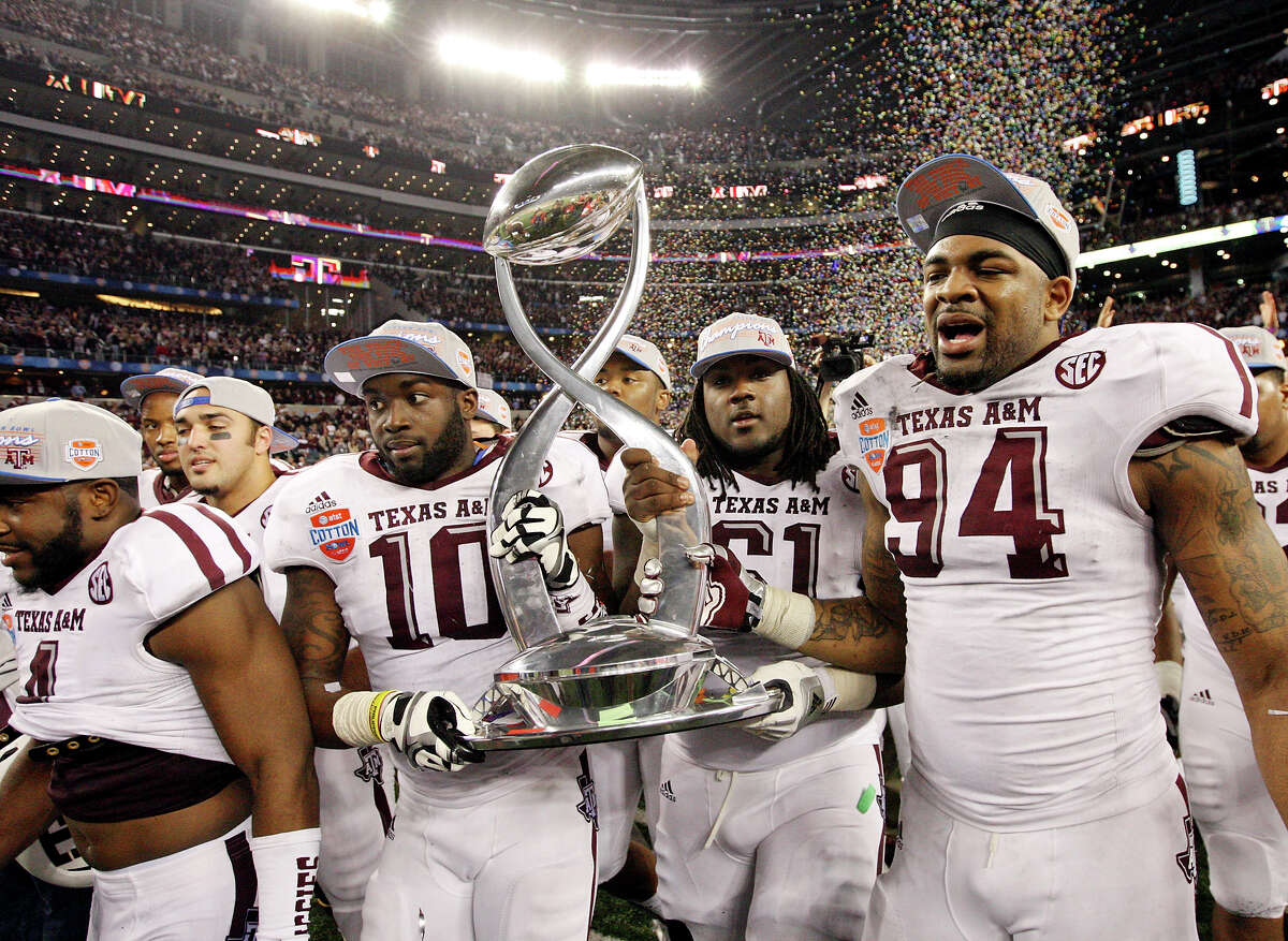 Members of the Texas A&M Aggies football team carry the trophy after the 77th AT&T Cotton Bowl Classic against the Oklahoma Sooners held Friday Jan. 4, 2013 at Cowboys Stadium in Arlington, Tx. The Aggies won 41-13.