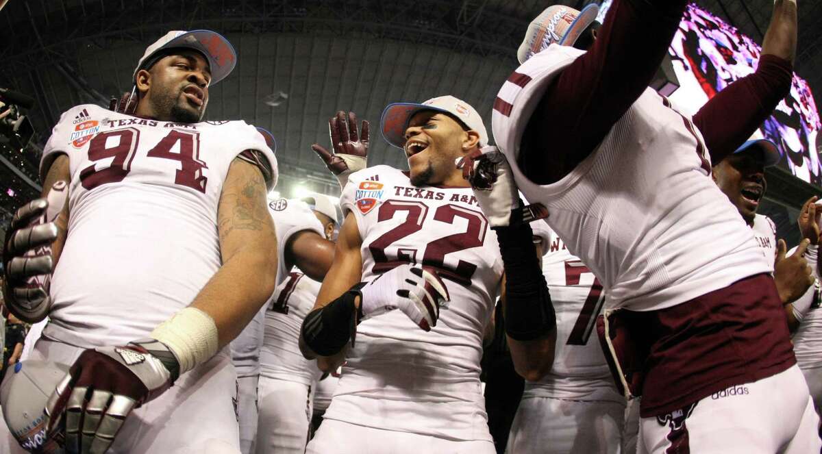 Texas A&M defensive back Dustin Harris (22) center, celebrates with Texas A&M defensive lineman Damontre Moore (94) and the rest of his team after beating Oklahoma in the Cotton Bowl, Friday, Jan. 4, 2013, in Cowboys Stadium in Arlington. Texas A&M won 41-13.