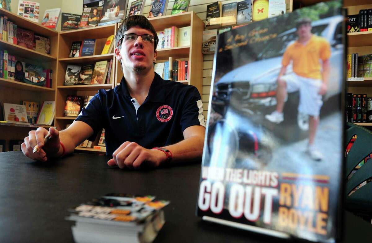 Ryan Boyle, a former Monroe resident and Traumatic Brain Injury survivor, signs copies of his autobiography "When the Lights Go Out" Saturday, Jan. 5, 2013 at Linda's Story Time in Monroe, Conn.
