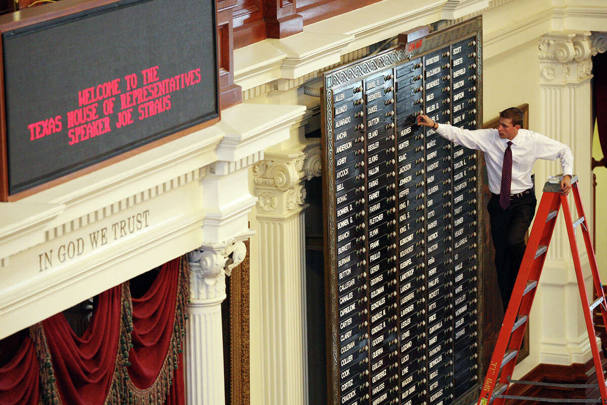 Texas House of Representatives assistant sergeant-at-arms Trevor Rice arranges names on the electronic voting board in the House Chambers at the State Capitol on Thursday in Austin. The 150-member house will have 44 newly elected members.