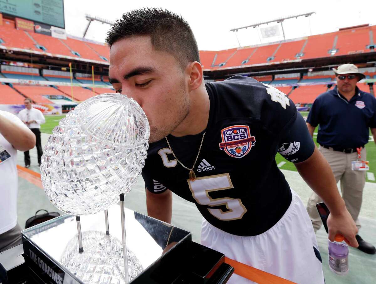 Notre Dame linebacker Manti Te'o on Saturday gets up close and personal with the Coaches' Trophy that will go to the winner of Monday night's national championship game between the top-ranked Irish and No. 2 Alabama.