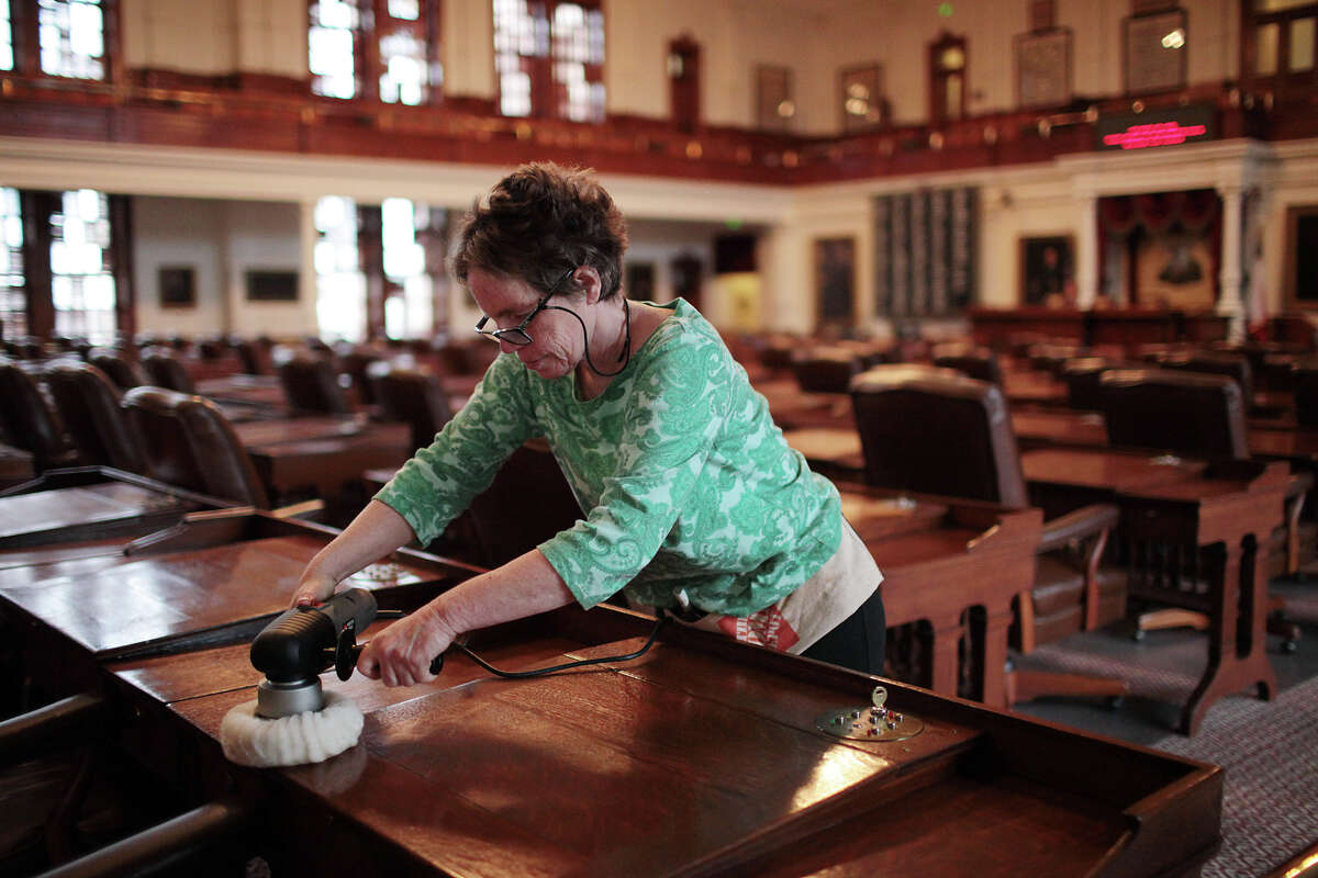 Contract worker Mara Eurich reconditions desks in the Texas House of Representatives last week. The Legislature will begin a new session Tuesday.