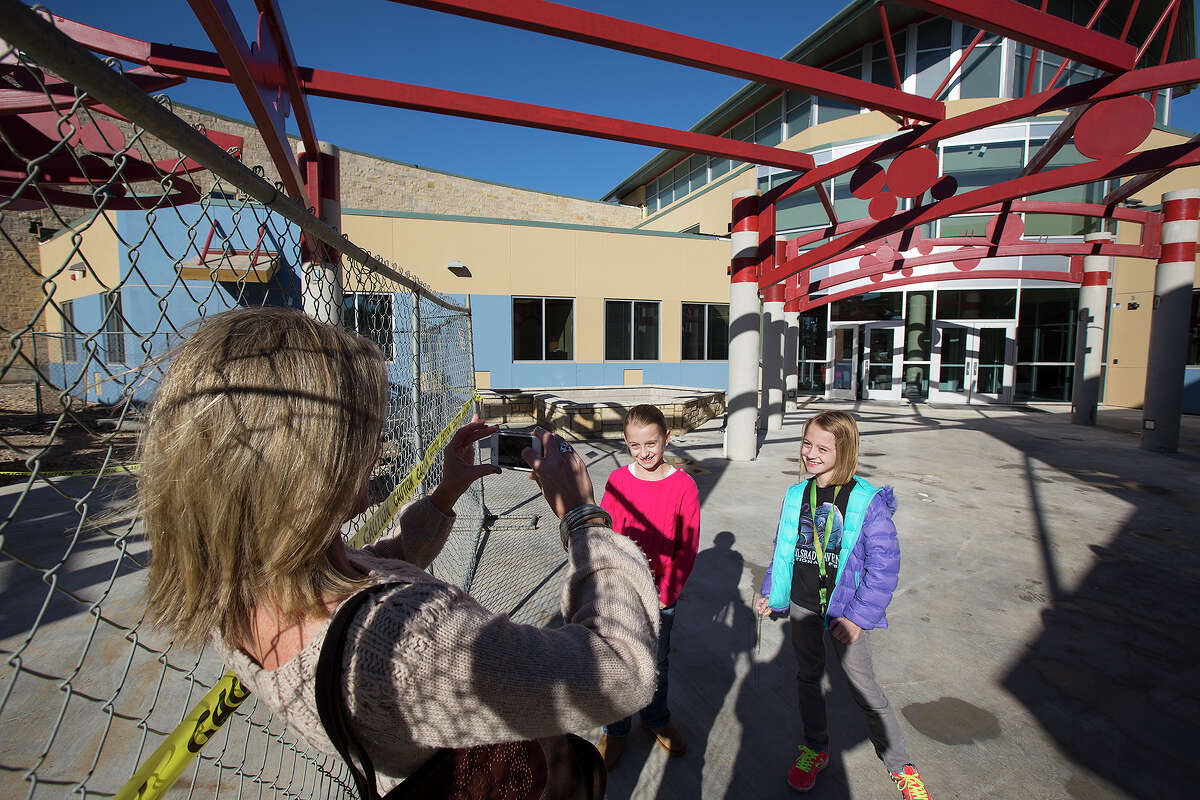 Holly Pearson takes a photo of 8-year-old twins Anna (center) and Ashleigh during the open house at Vineyard Ranch Elementary School at 16818 Huebner Road. The open house was so well-attended, officials ran out of the maps they’d printed.