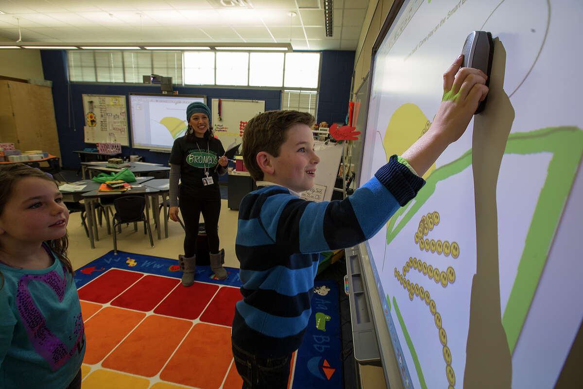Rob McKenna, 9, interacts with SMART technology in AnaLisa Chadwell’s classroom as Lauren McKenna, 7, and Chadwell watch during the Vineyard Ranch open house.