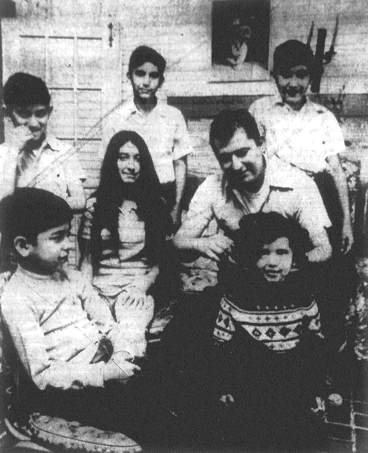 Michael Chapa Jr., a lieutenant inspector with the San Antonio Fire Department, combs daughter Leticia's hair, under the watchful eyes of his children Raul (foreground), Cynthia (next to Chapa), Frank (rear, from left), Gabriel and Michael. Chapa's wife, Virginia, died Dec. 21 in childbirth with the couple's seventh child. Christmas "went on as usual" for the family. "I told the kids their mother would have wanted it that way," Chapa said. Published in the San Antonio Light Jan. 1, 1973.