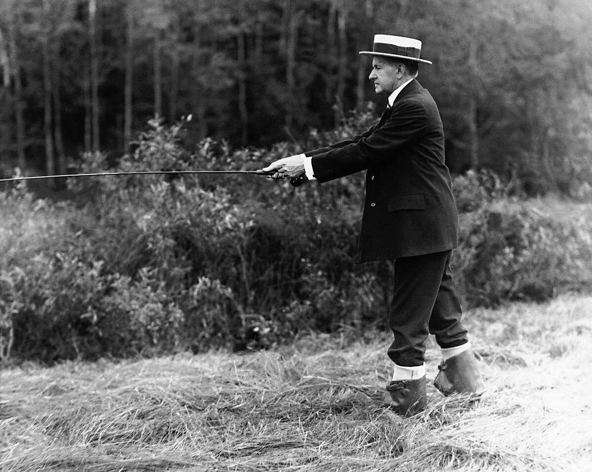 Former President Calvin Coolidge appears in a straw hat and rubber boots in a stream near the Coolidge family homestead in Plymouth, Vt., on July 14, 1931. A number of the speckled denizens left Plymouth streams for the frying pan after Coolidge returned for a brief vacation.