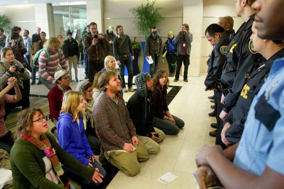 Protestors sit in the lobby of a building in the 2700 block of Post Oak Blvd., containing an office for the company Keystone XL, Monday, Jan. 7, 2013, in Houston. Members of the Tar Sands Blockade are protesting the company for their involvement with TransCanada and the building of the Keystone XL Pipeline. The group says that the pipeline running from Canada to Texas contains toxic chemicals. (Cody Duty / Houston Chronicle)