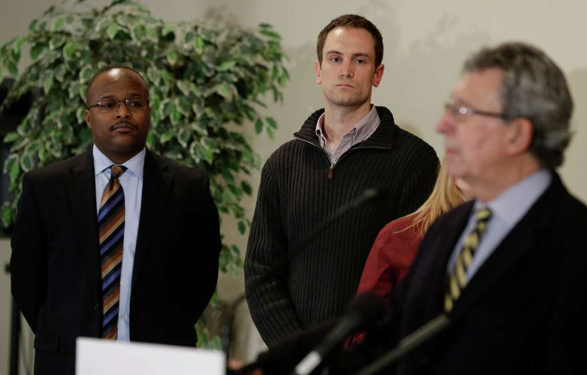 Aaron Williams, left, pastor of Mount Zion Baptist Church, and Ty Rogers, center, corporate communications manager for Amazon.com, listen Tuesday, as former Seattle Mayor Charles Royer, right, speaks at a news conference to announce a new gun buyback program that will begin later in January, 2013, in Seattle. Amazon, a Seattle-based online retailer, is donating $30,000 in gift cards, which will be paid to people who turn in guns during the buyback program. (AP Photo/Ted S. Warren)