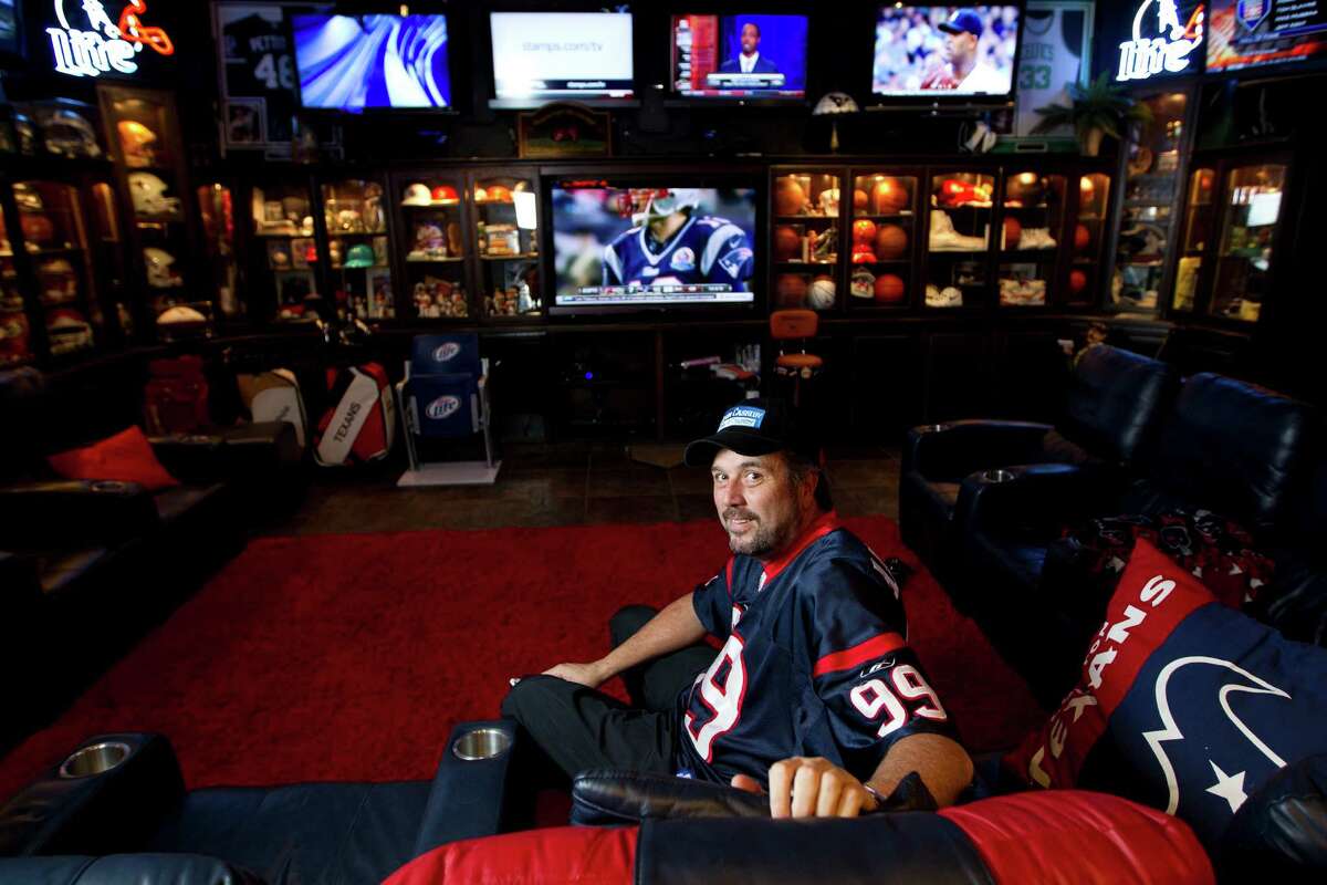 Diehard Texans fan Blake Barnes' "Blake's Place" in Deer Park can seat about 50 people and features multiple televisions and cabinets full of sports memorabilia. Below, a detail of one of many signed footballs on display in the 1,300-square-foot space.
