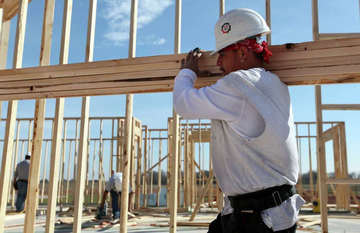 Richard Gonzales carries lumber while constructing a home in a Sugar Land subdivision. Metrostudy projects that housing starts in the Houston area will grow by about 17 percent this year, to as many as 27,500 homes.