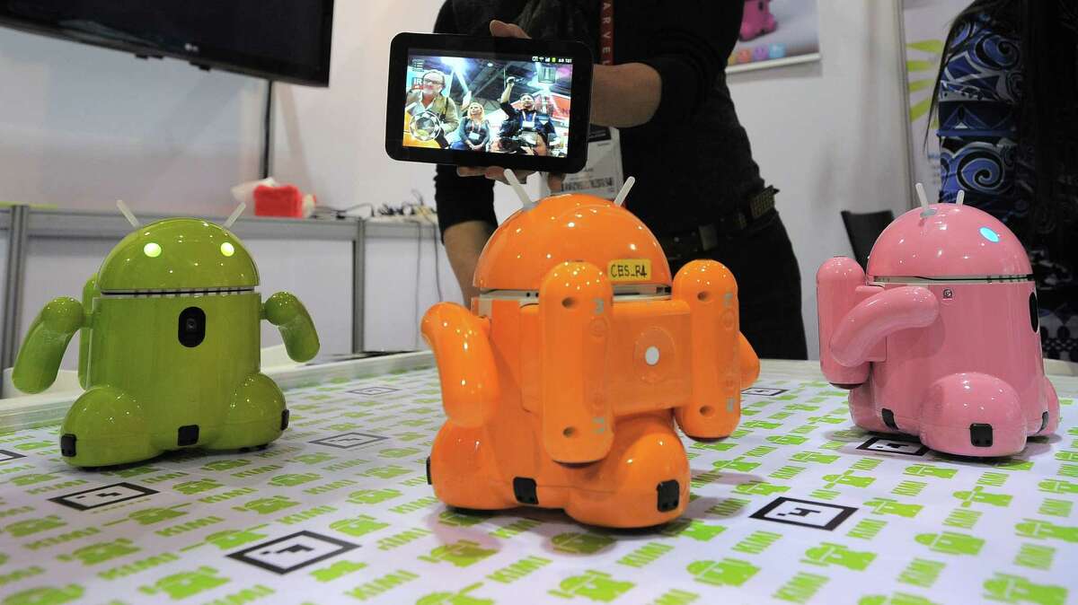 Mike Kim from Korea's Roboware operates smart device controlled toy robots are displayed at the 2013 International CES at the Las Vegas Convention Center on January 9, 2013 in Las Vegas, Nevada. CES, the world's largest annual consumer technology trade show, runs from January 8-11 and is expected to feature 3,100 exhibitors showing off their latest products and services to about 150,000 attendees.AFP PHOTO / JOE KLAMARJOE KLAMAR/AFP/Getty Images