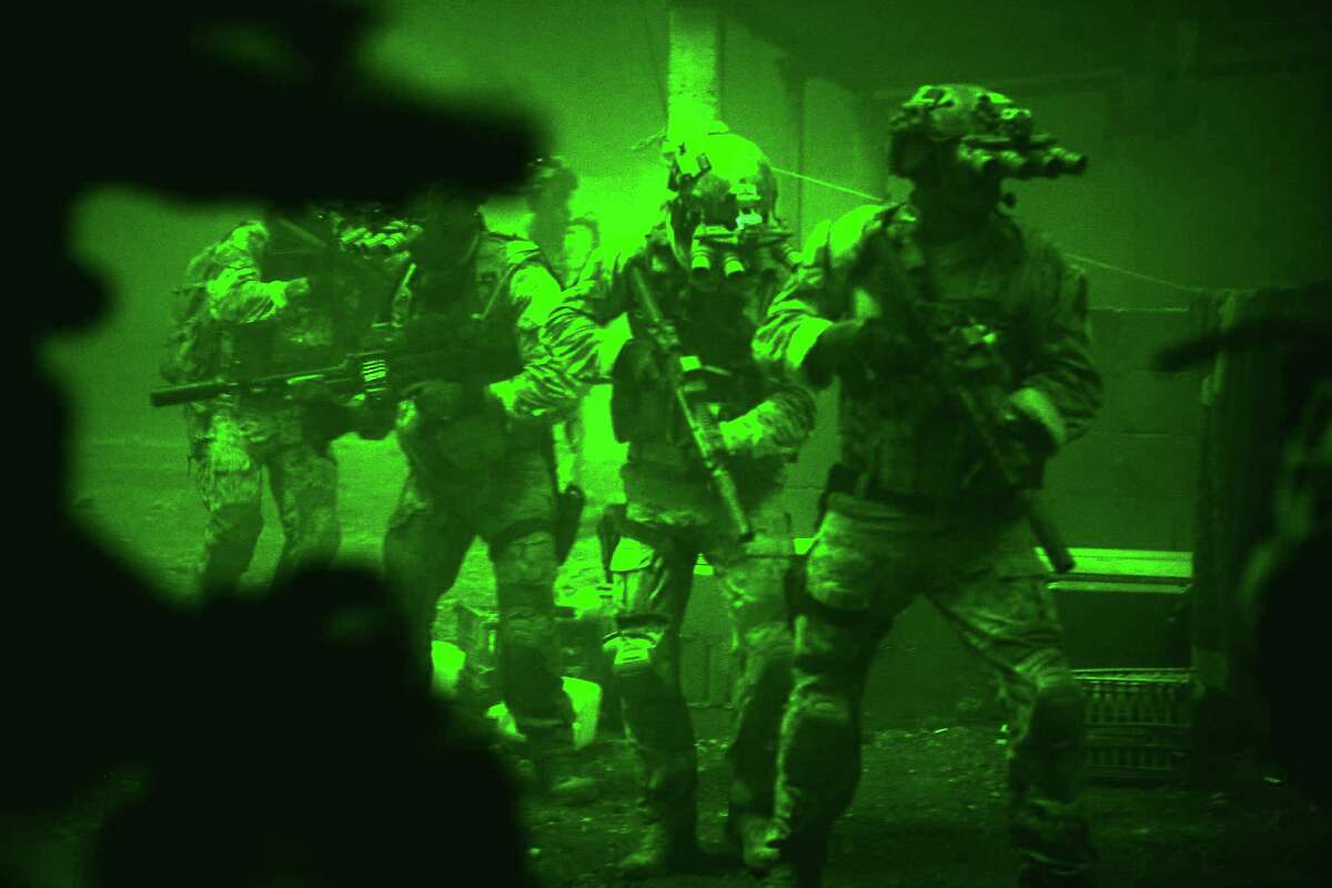 This undated publicity photo released by Columbia Pictures Industries, Inc. shows Navy SEALs seen through the greenish glow of night vision goggles, as they prepare to breach a locked door in Osama Bin Laden's compound in Columbia Pictures' hyper-realistic new action thriller from director Kathryn Bigelow, "Zero Dark Thirty." (AP Photo/Columbia Pictures Industries, Inc., Jonathan Olley)