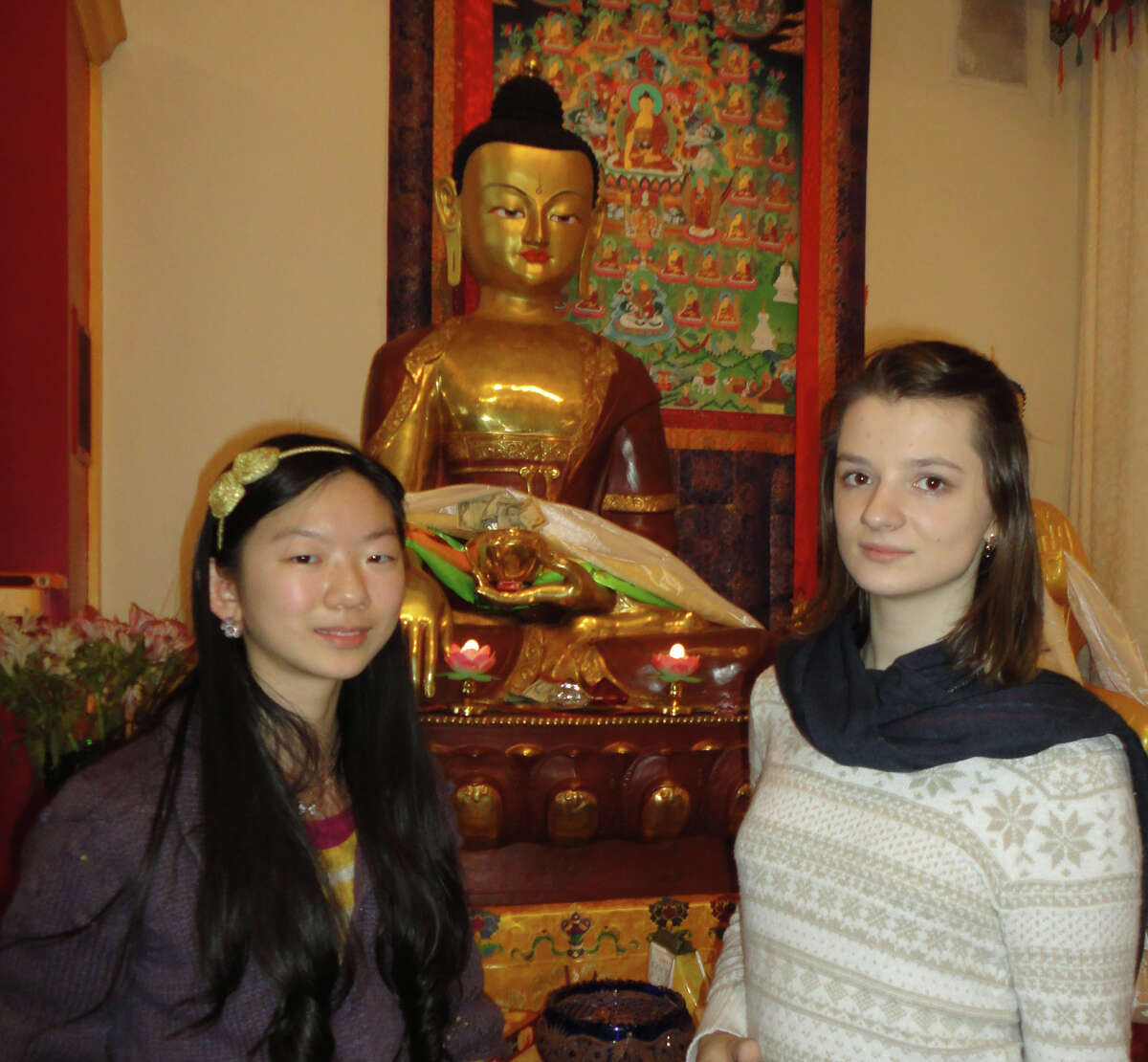 Chiana Yang, left, 14, and Alisa Korneyeva, 15, freshmen at Fairfield Warde High School, in front of a statue of Buddha at the Tibetan Buddhist Center for Universal Peace in Redding, which they visited Tuesday. Fairfield CT 1/8/13