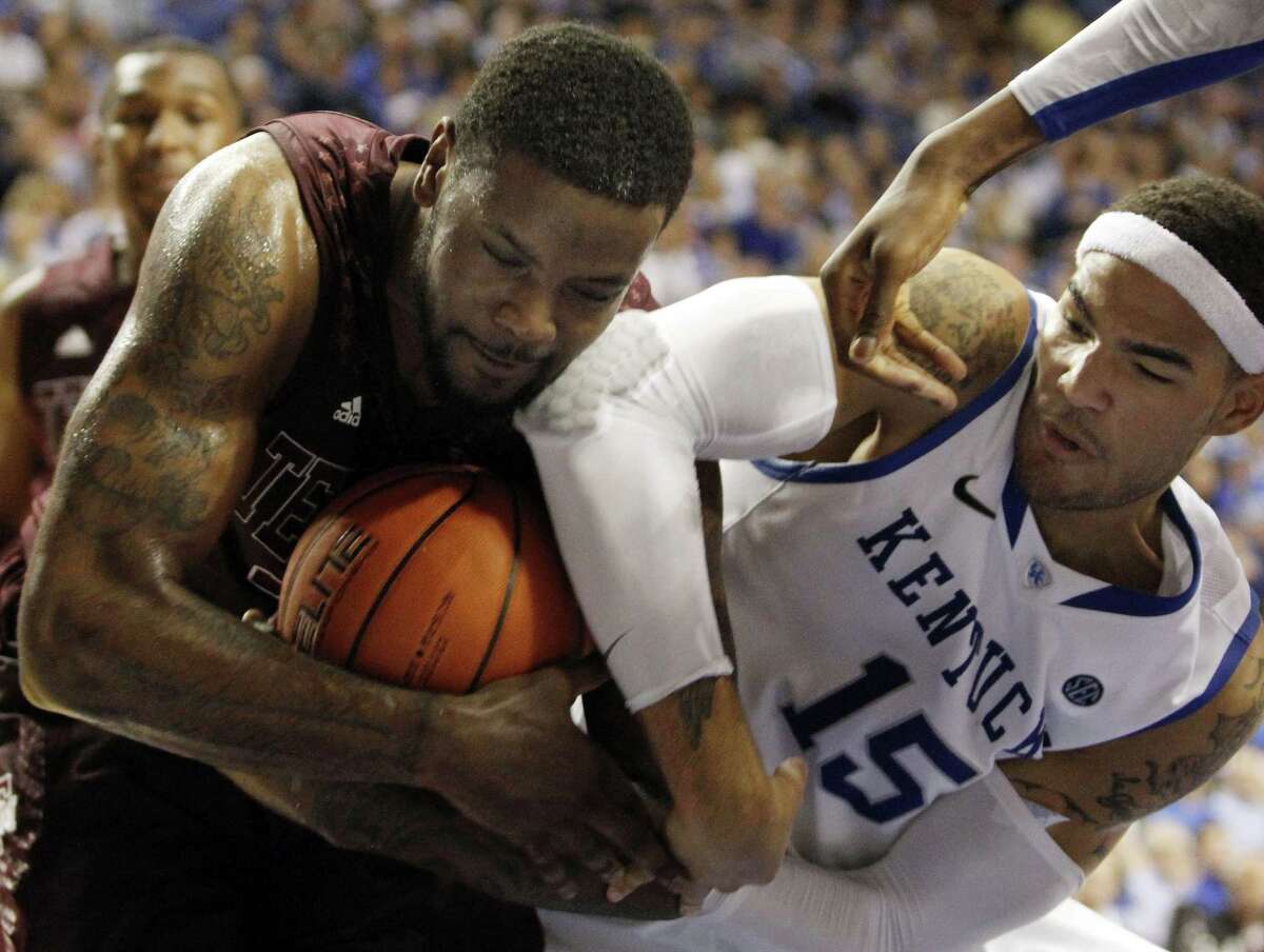 Texas A&M's Kourtney Roberson, left, is pressured by Kentucky's Willie Cauley-Stein during the second half of an NCAA college basketball game at Rupp Arena in Lexington, Ky., Saturday, Jan. 12, 2013. Texas A&M defeated Kentucky 83-71. (AP Photo/James Crisp)