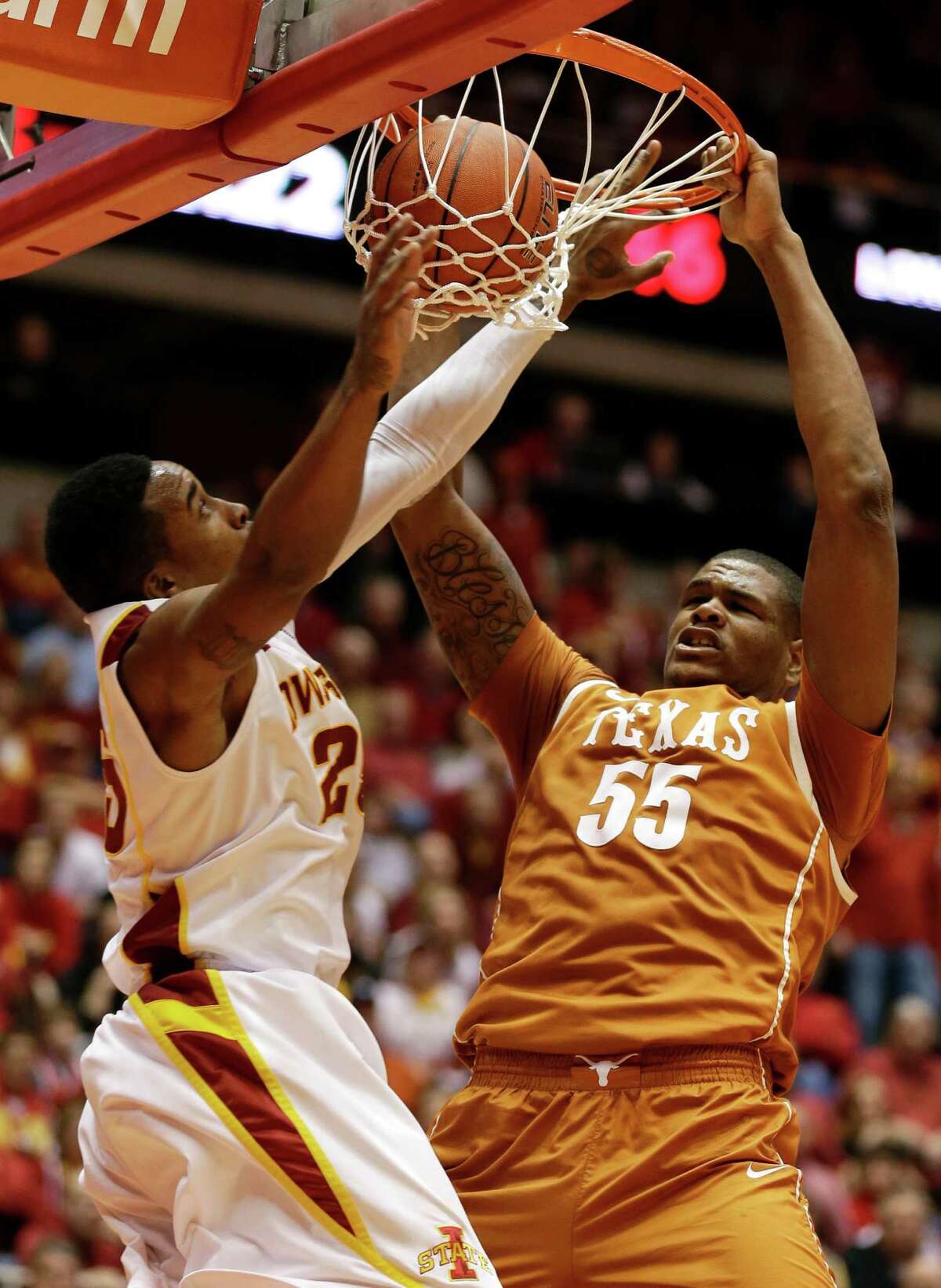 Texas center Cameron Ridley (55) dunks the ball over Iowa State guard Tyrus McGee, left, during the second half of an NCAA college basketball game, Saturday, Jan. 12, 2013, in Ames, Iowa. Iowa State won 82-62. (AP Photo/Charlie Neibergall)
