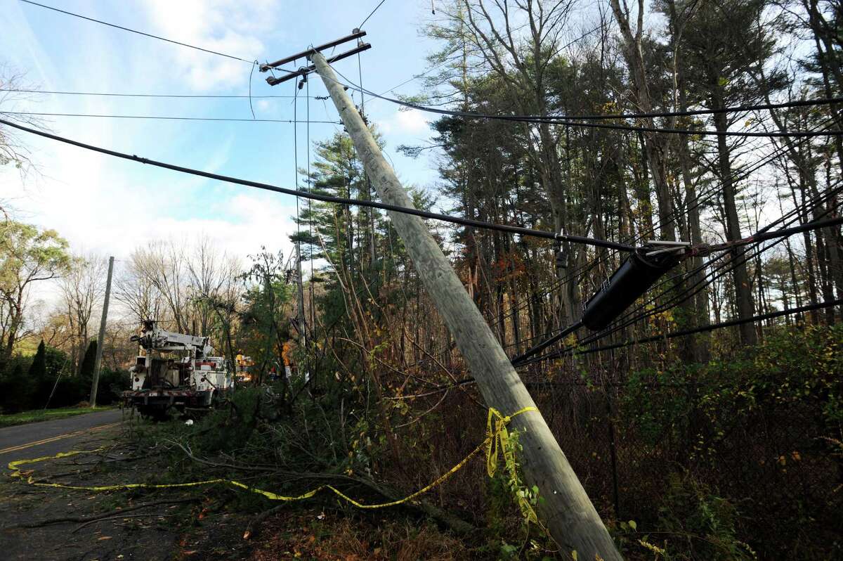 Crews from Connecticut Light & Power, AT&T and a tree crew from North Carolina work to clear a road near Stamford, Conn.