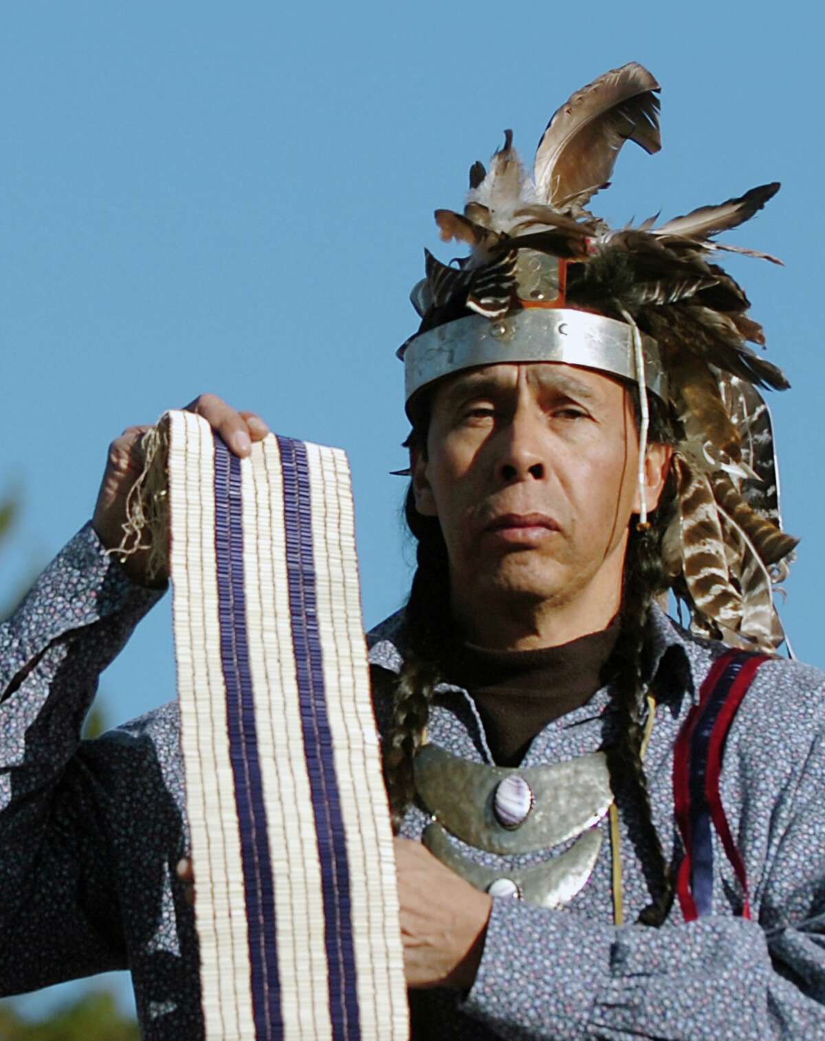Tadodaho Sidney Hill stands on the shore of Onondaga Lake holding a replica of Guswenta, the Two Row Wampum Belt. Following tradition throughout time, all men holding the title of Tadodaho have been Onondaga. The Two Row Wampum records the treaty made with the Dutch in 1613. It is the basis for all Haudenosaunee relationships with foreign governments. (John Berry/The Post-Standard)