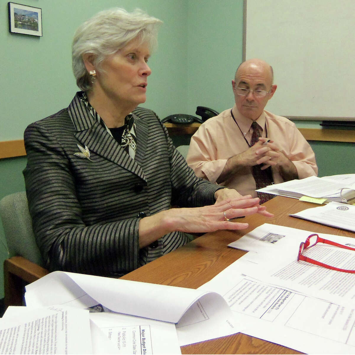 Milford Supt. of Schools Elizabeth Feser, flanked by school system CEO James L. Richetelli Jr., reviews her proposed $88.9 million 2013-14 budget with members of the press this week. Her budget would eliminate 10 teaching positions because of declining enrollment, but it also adds positions needed to keep pace with new state regulations on teacher reviews.