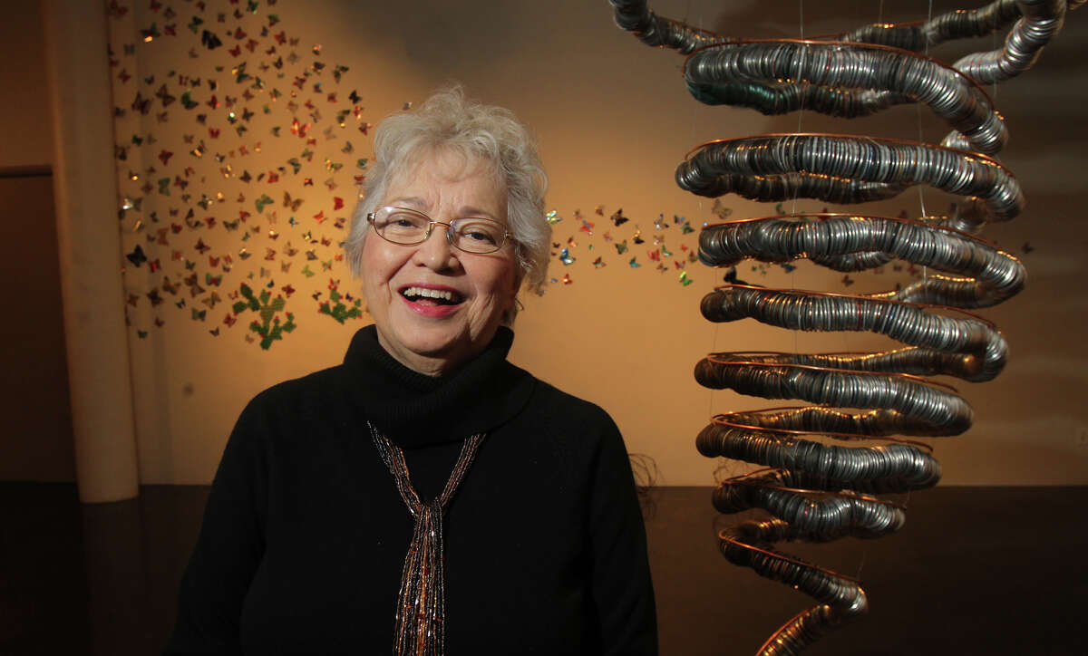 Local artist Anita Valencia stands by her exhibit on display at the Southwest School of Art's Russell Hill Rogers Gallery. Valencia's works of art are made from aluminum cans and depict a tornado, stars, butterflies and other objects.