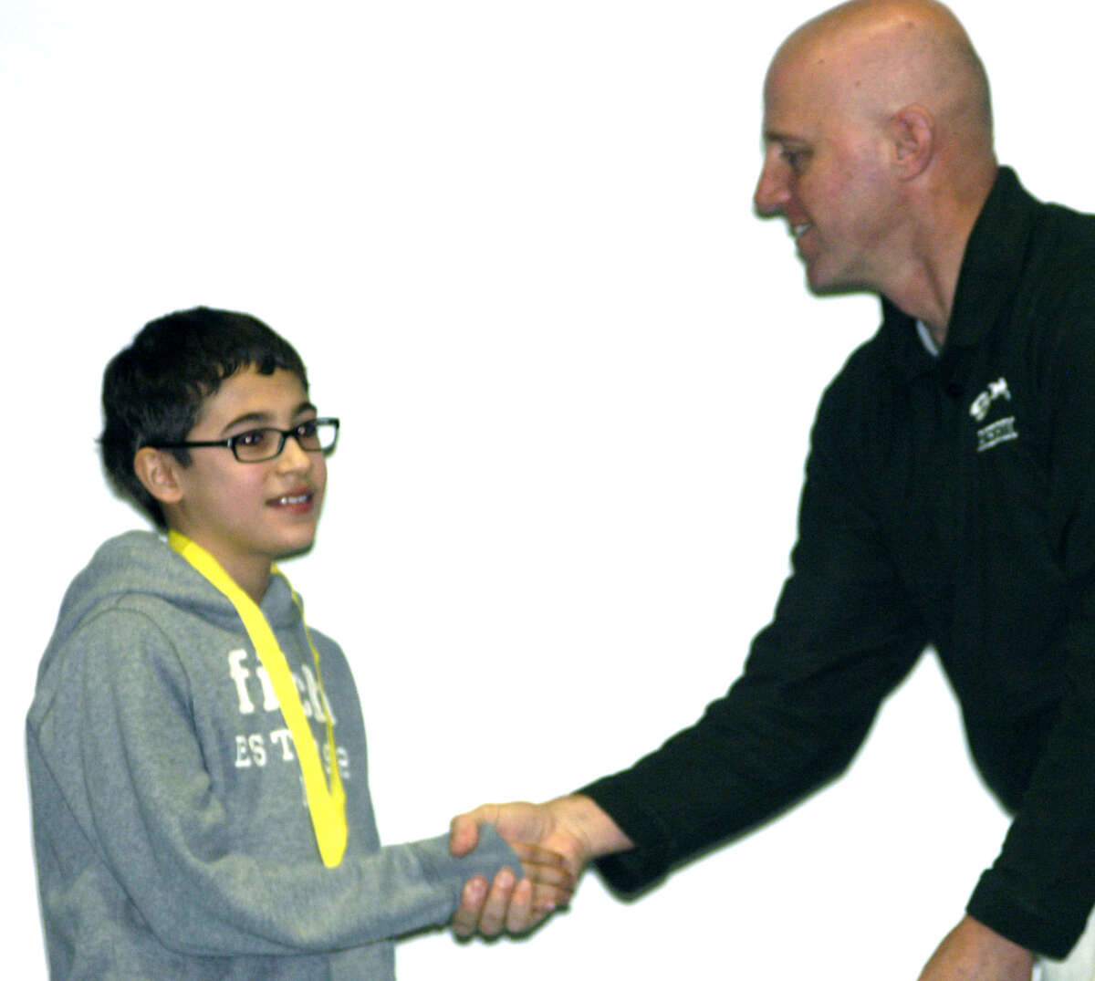 Nick Edwards, a seventh-grade student at Schaghticoke Middle School in New Milford, accepts faculty moderator Rob Hibbard's congratulations after winning his school's edition of the National Geographic geography bee. Jan. 4, 2013