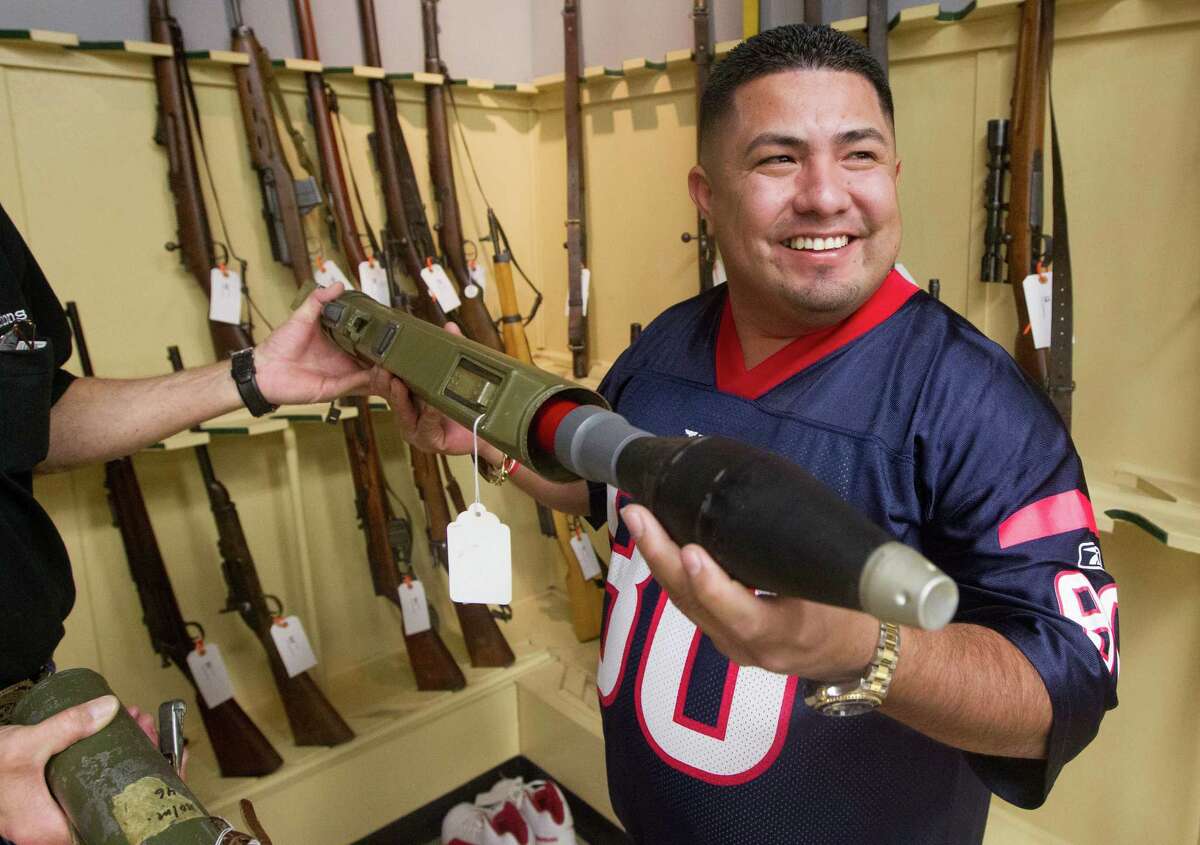 Saul Silva puts a replica shell into his new "conversation piece," an M72A3 antitank rocket-launcher, at Saturday's auction of the personal collection of the late Bill James, founder of the Arms Room in League City.