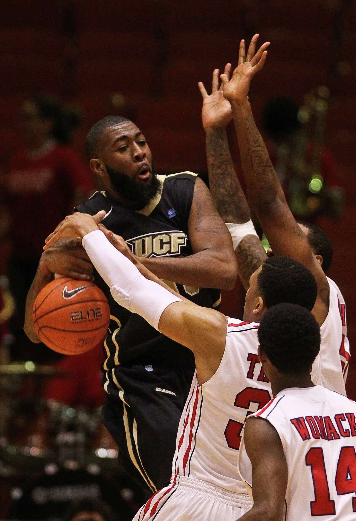 Houston's TaShawn Thomas gets a little more than the ball as he defends against UCF's Keith Clanton in the second half.