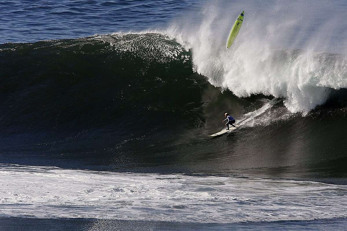 Ryan Augenstein drops in on a wave as Josh Loya wipes out at Mavericks Surf Competition in Heat 3 on January 20, 2013 in Half Moon Bay, Calif.