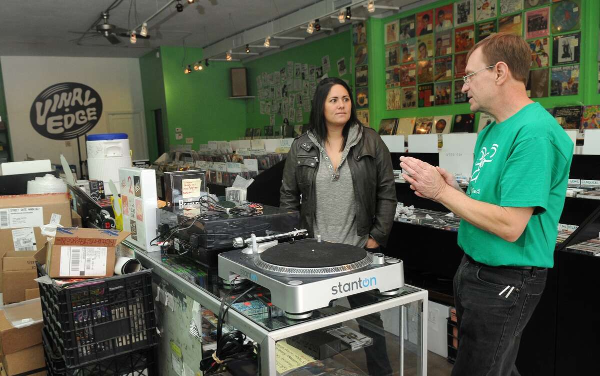 Veronica Caycedo discusses turntables with Chuck Roast, owner of Vinal Records in the Heights.