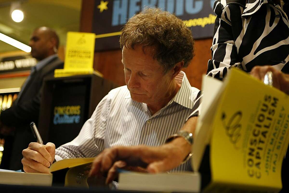 John Mackey signs a copy of his book, "Conscious Capitalism: Liberating the Heroic Spirit of Business" during a book signing at the Whole Foods in Potrero on January 22, 2013 in San Francisco, Calif. Mackey is both co-founder and co-CEO of the Whole Foods supermarket chain.