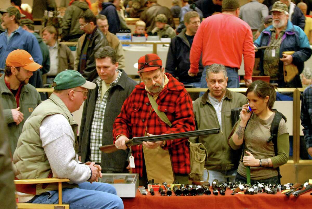 Michael Thomas of Kingston, center in red plaid, looks over an AH Fox double barrel shotgun Saturday, Jan. 20, 2007, during a gun show at the Empire State Plaza Convention Center in Albany, N.Y. (Cindy Schultz/Times Union archive)