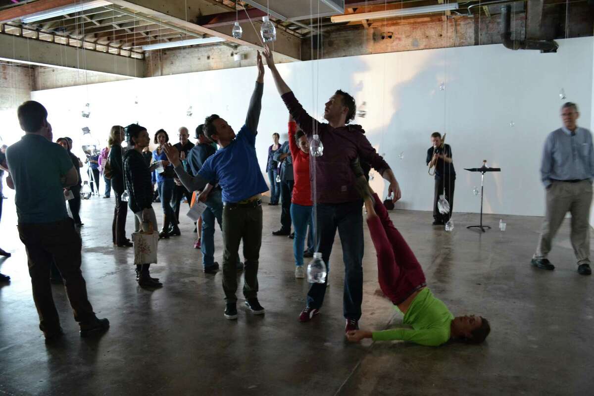 Dancers Spencer Gavin Herring, from left, jhon stronks and Leslie Scates perform in the center of artist Tony Feher's installation "Free Fall" during the opening weekend of the exhibit, which features a series of live performances. Trombonist David Dove is in the background.